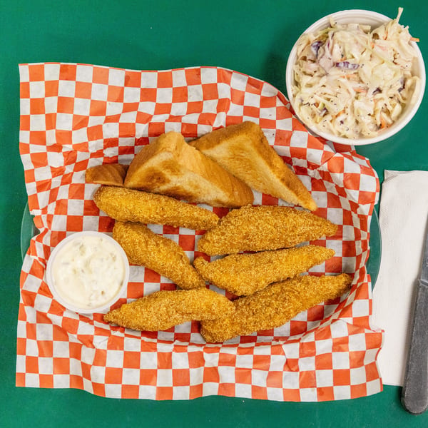 Fried fish fillets, toast, tartar sauce, and coleslaw served in a basket with checkered paper.
